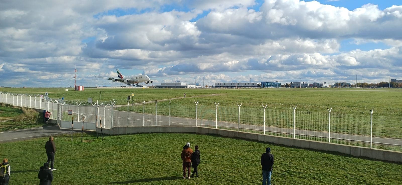 Airbus A380 společnosti Emirates přistává na letišti v Praze před skupinou leteckých fanoušků