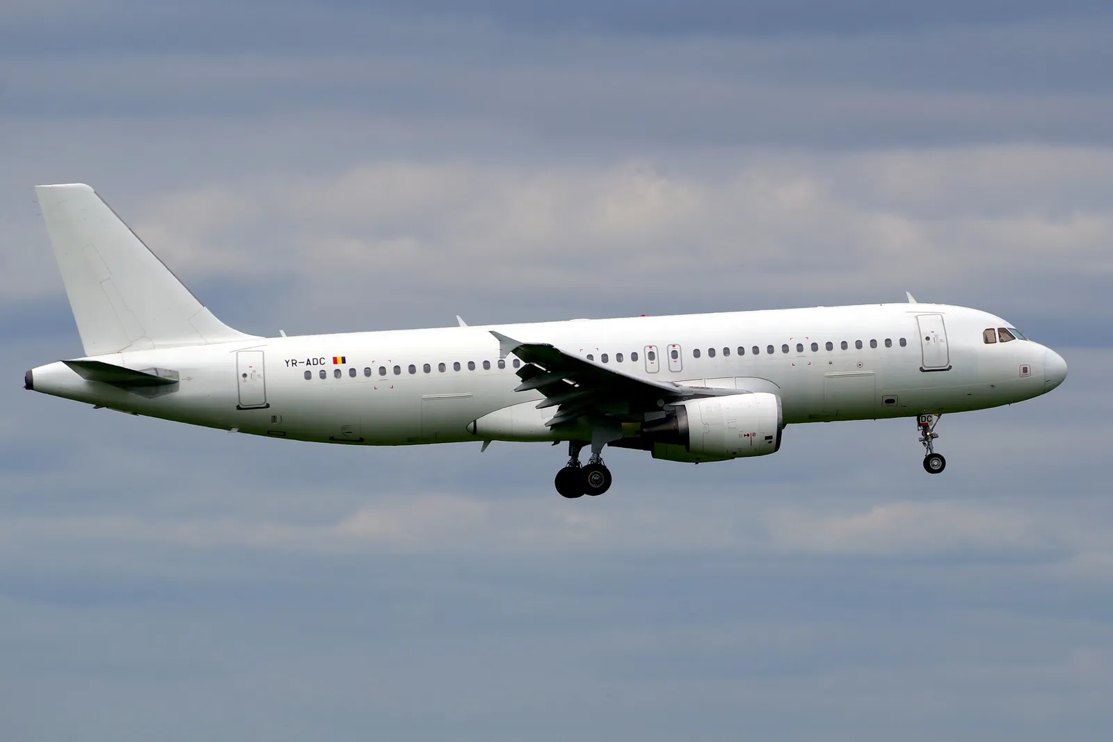 Bílý Airbus A320 s registrací YR-ADC dopravce FLYYO při přistání