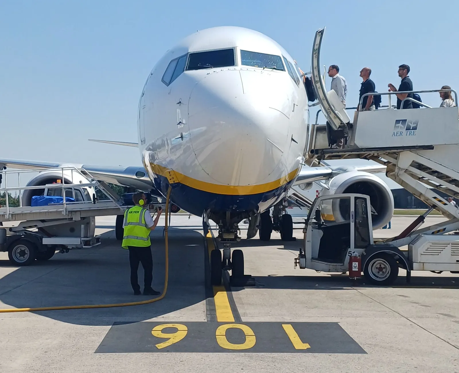 Boeing 737 Ryanair zepředu, cestující nastupují po schodech s logem AER TRE