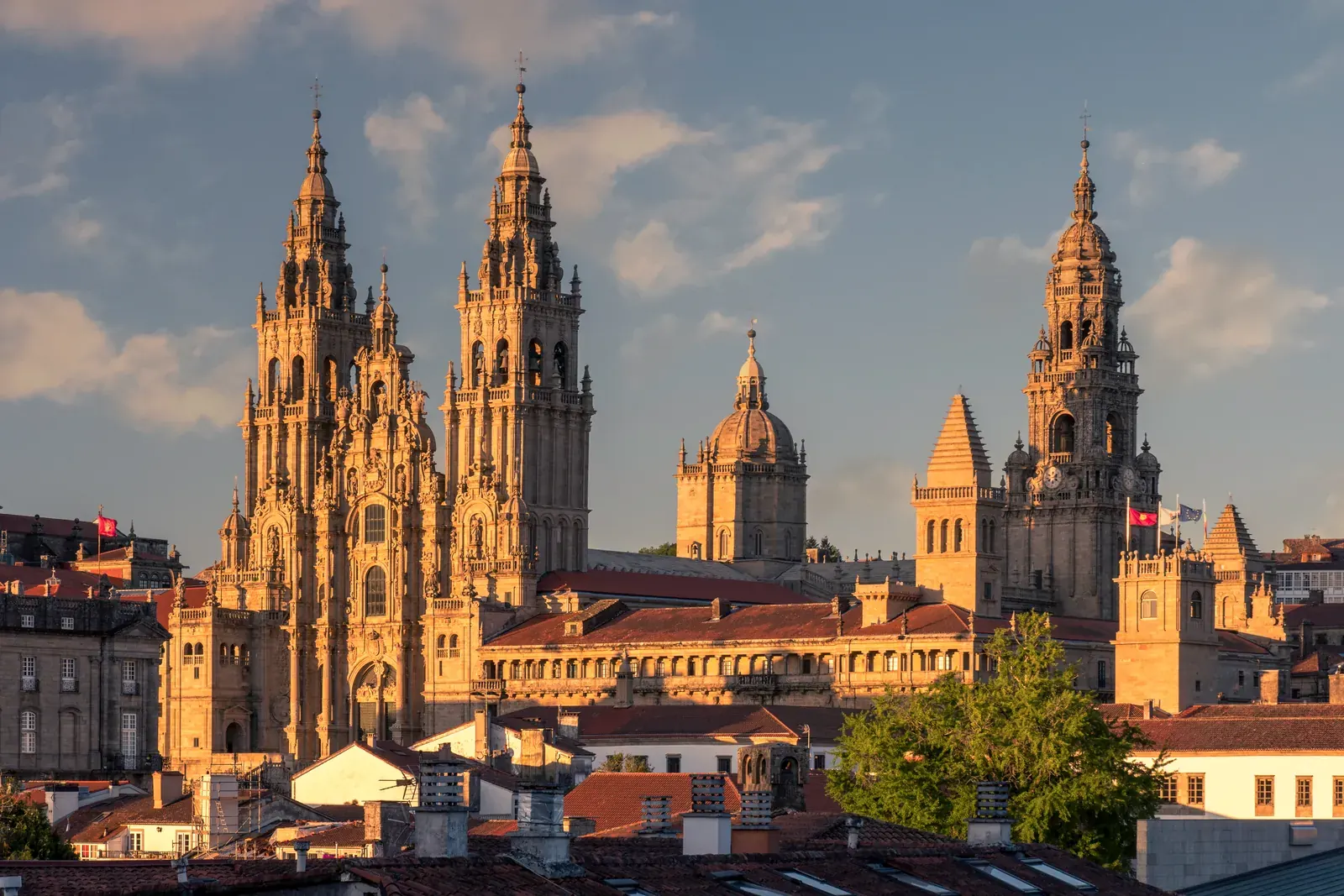 Věže katedrály v Santiagu de Compostela nad střechami starého města ve večerním světle